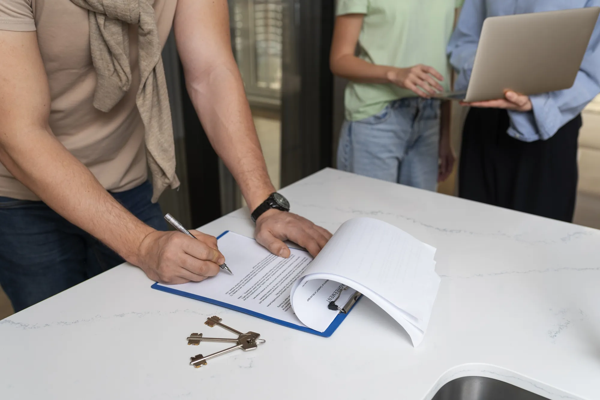 Side view of a buyer signing a printed document at a desk