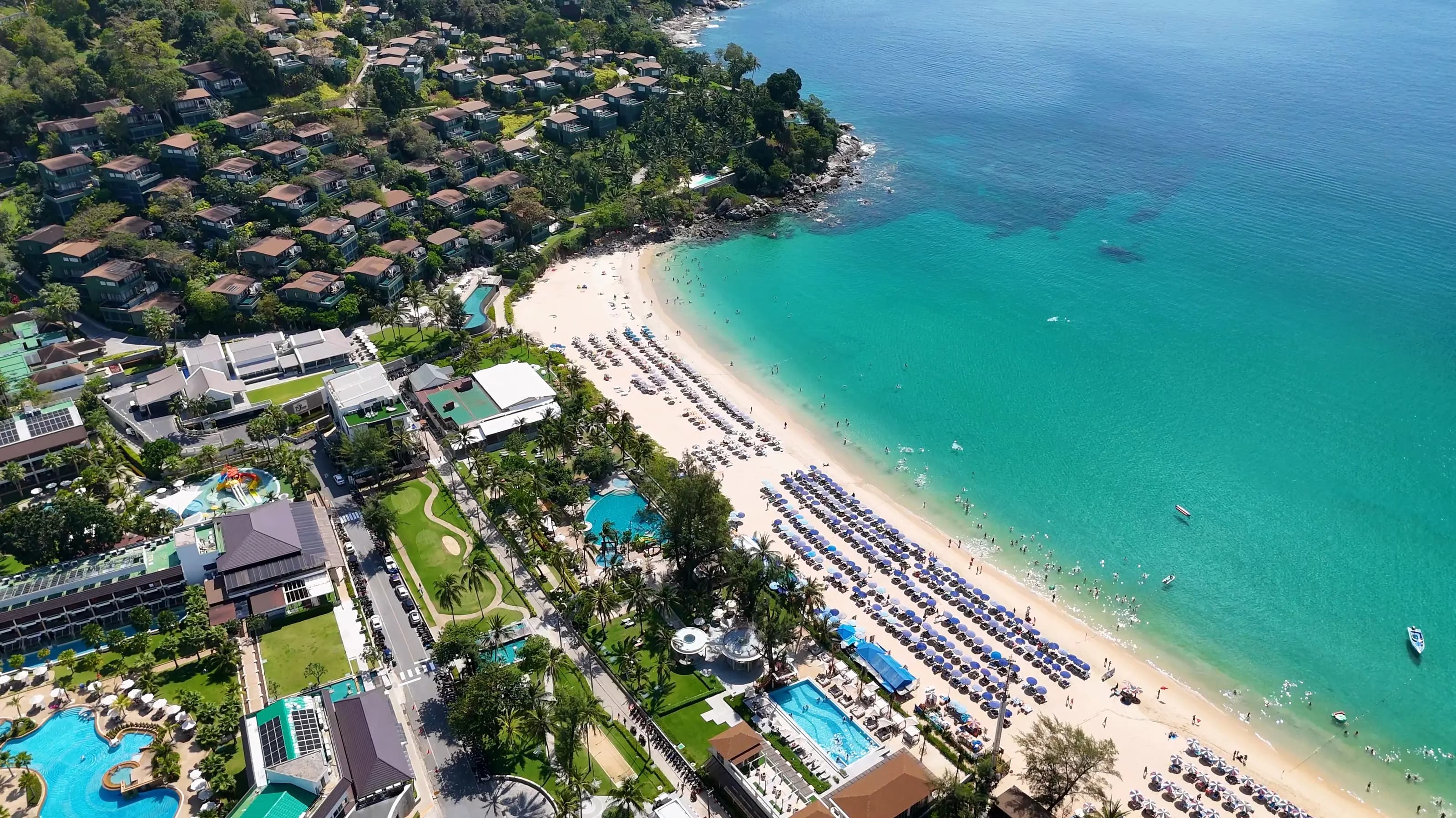 Aerial view of a Phuket beach with hillside villas and beachfront resorts