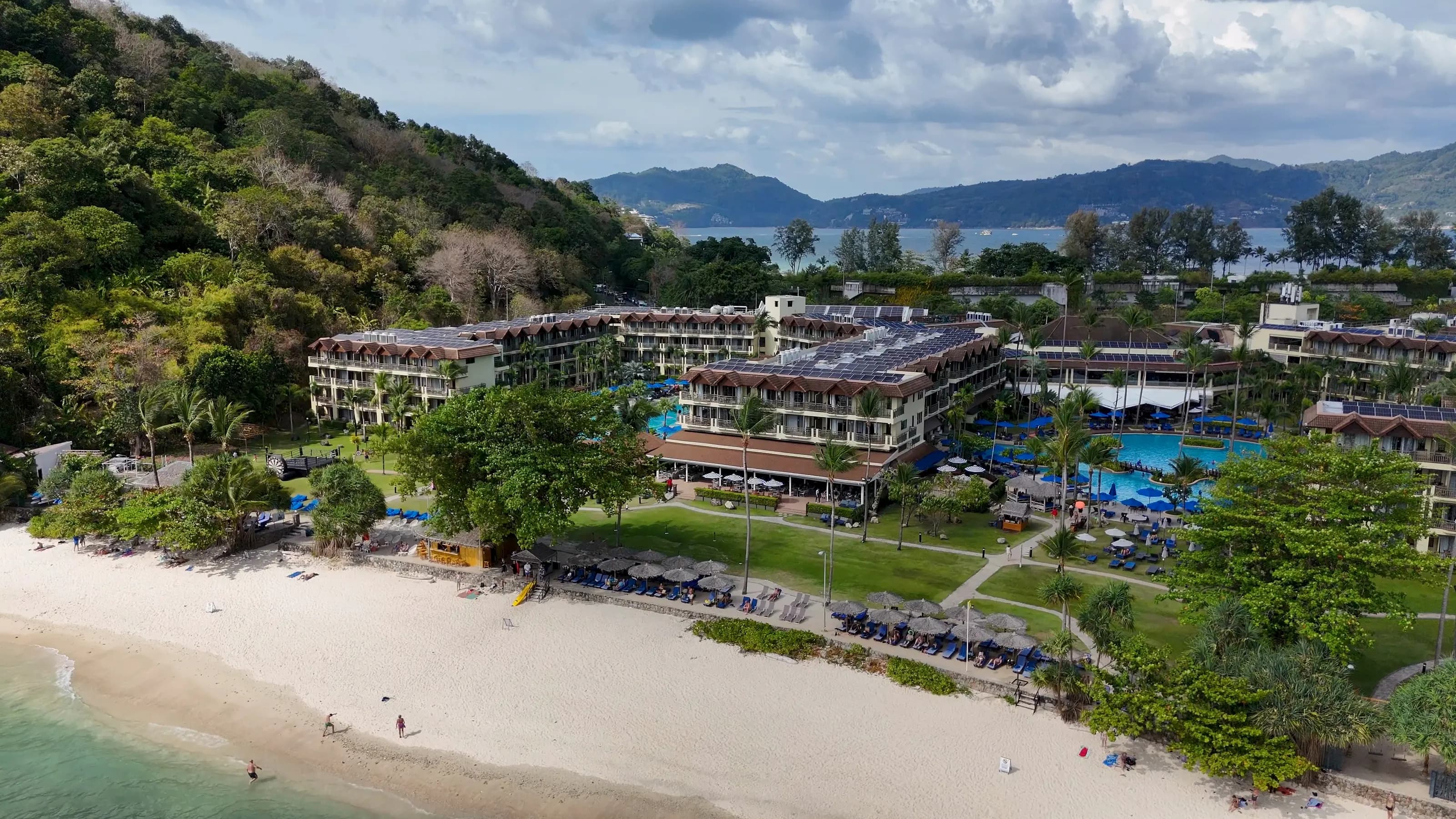 Aerial view of a beachfront resort in Phuket, with gardens and pools